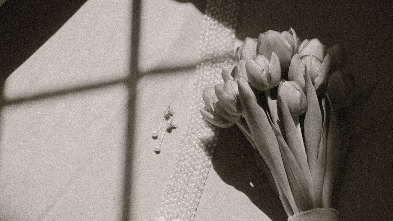 Tulipanes, perlas y unos pendientes junto a la luz de una ventana