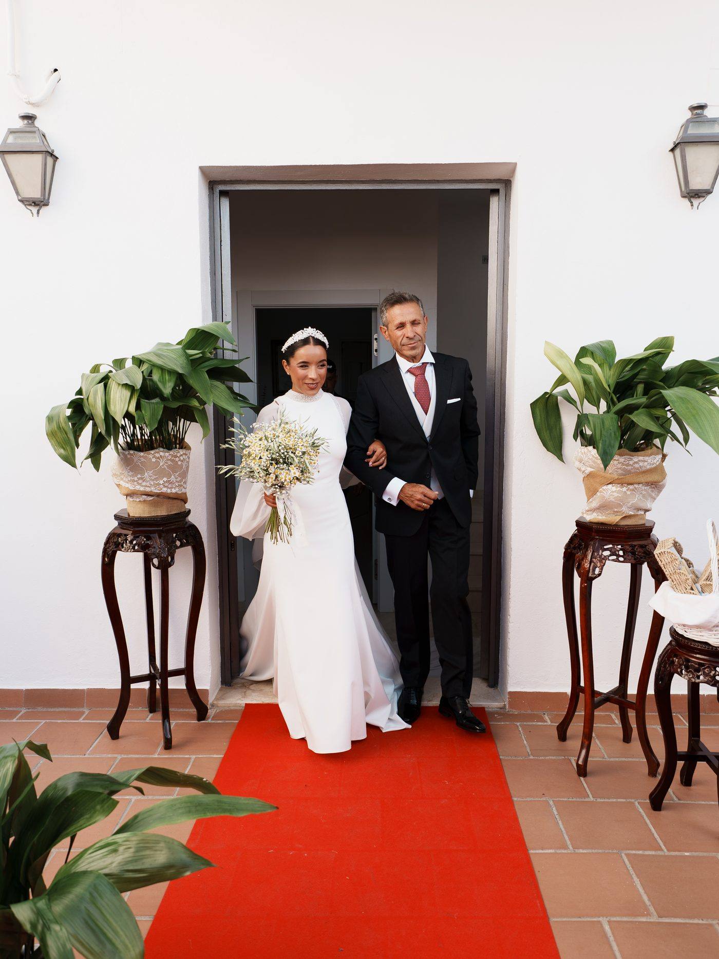 La novia saliendo de casa del brazo de su padre