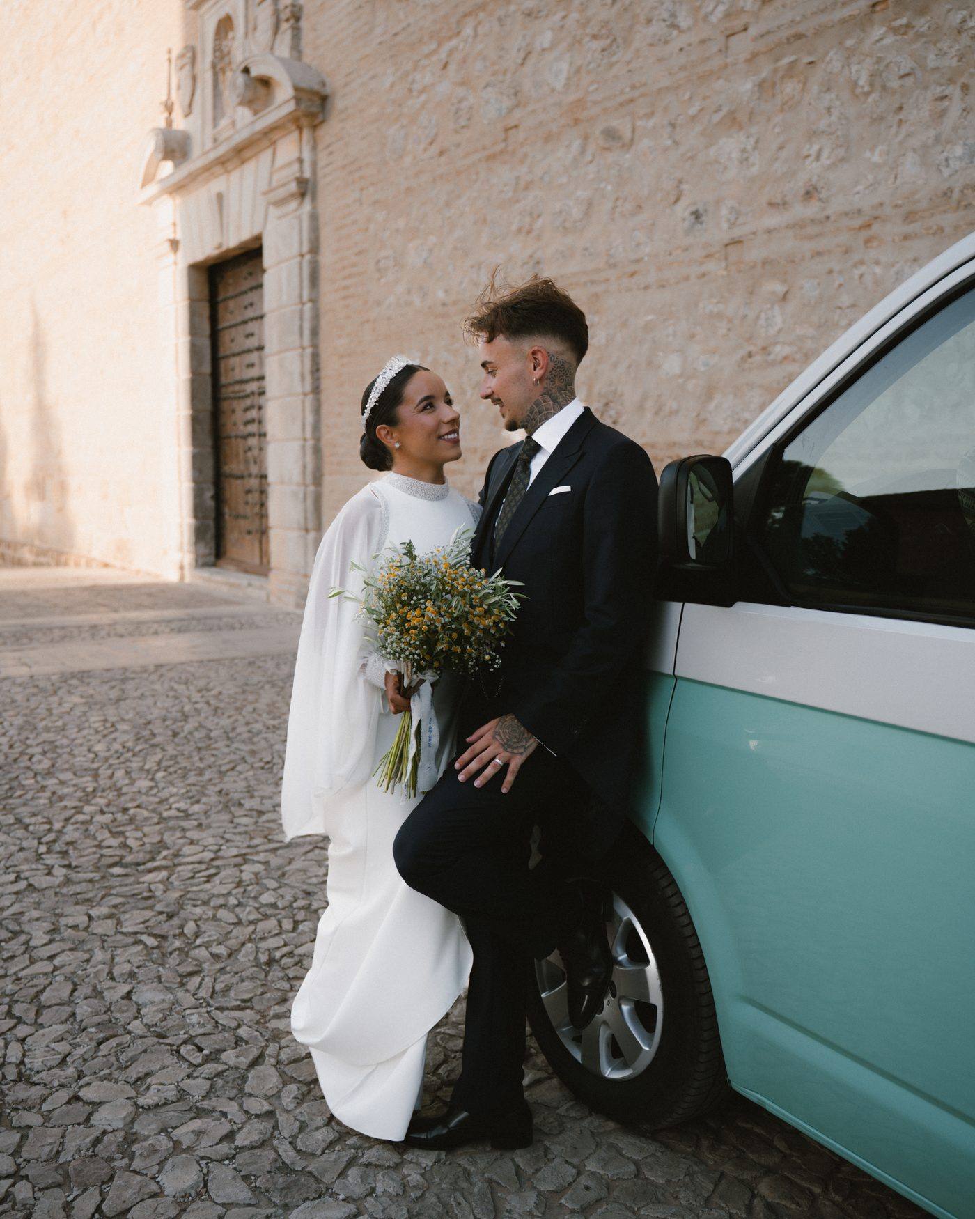 Los novios apoyados en la furgoneta, frente a la iglesia
