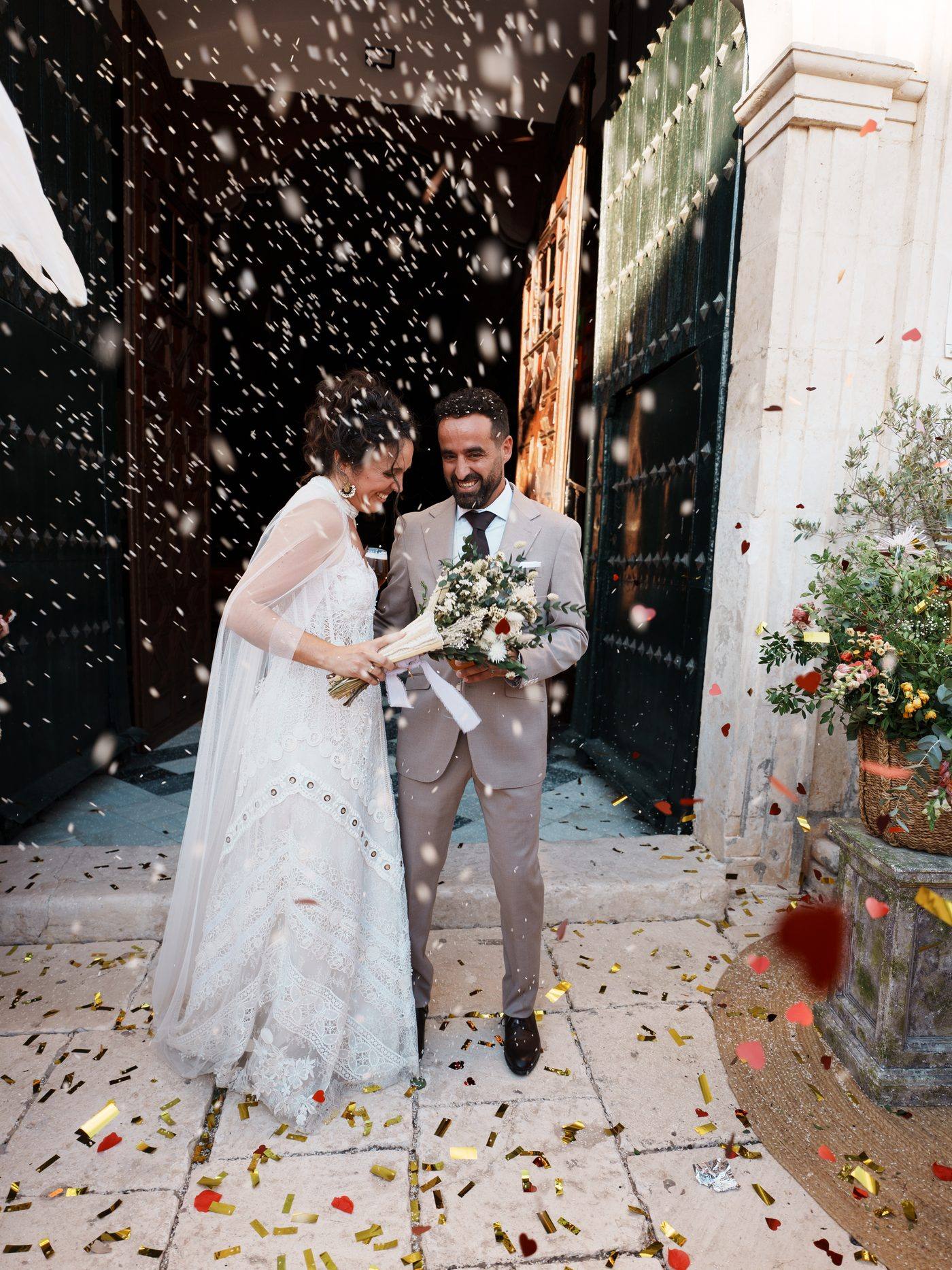 Los novios saliendo de la iglesia bajo una lluvia de confeti