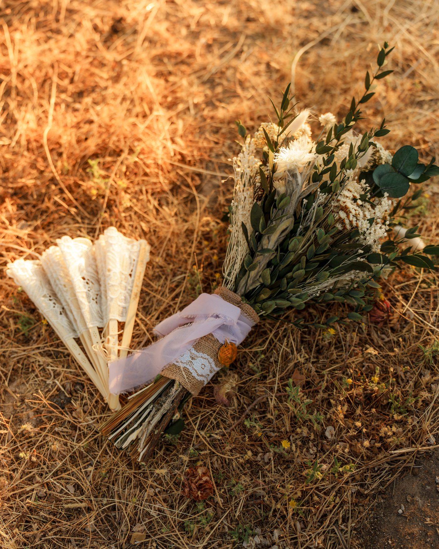 El ramo de flores secas y los abanicos de encaje sobre la hierba