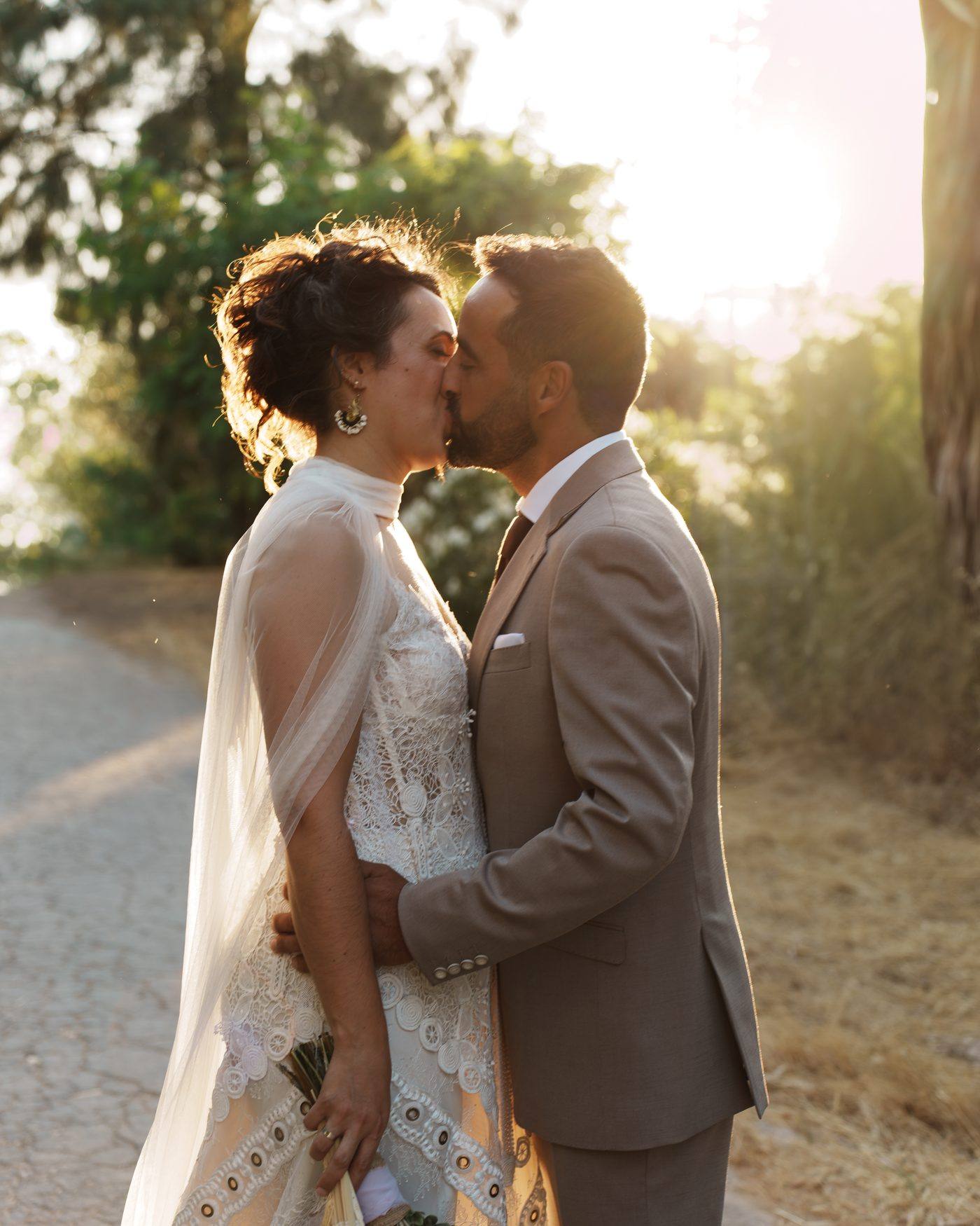 El beso de los novios en el camino, a contraluz